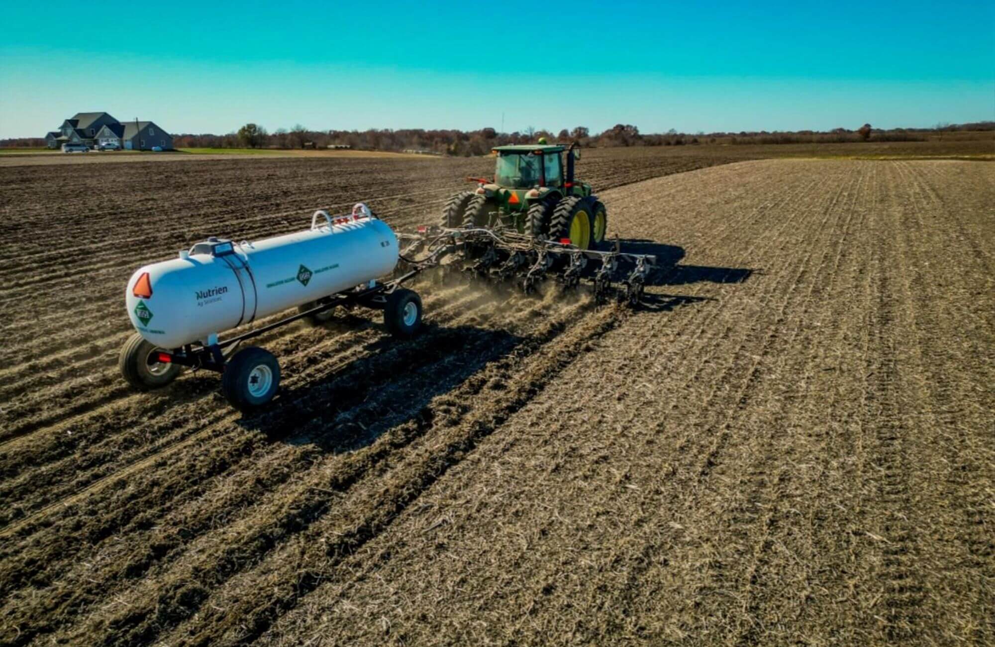John Deere Tractor Fertilizing Field with Nutrien Anhydrous Tank & Precision Applicator