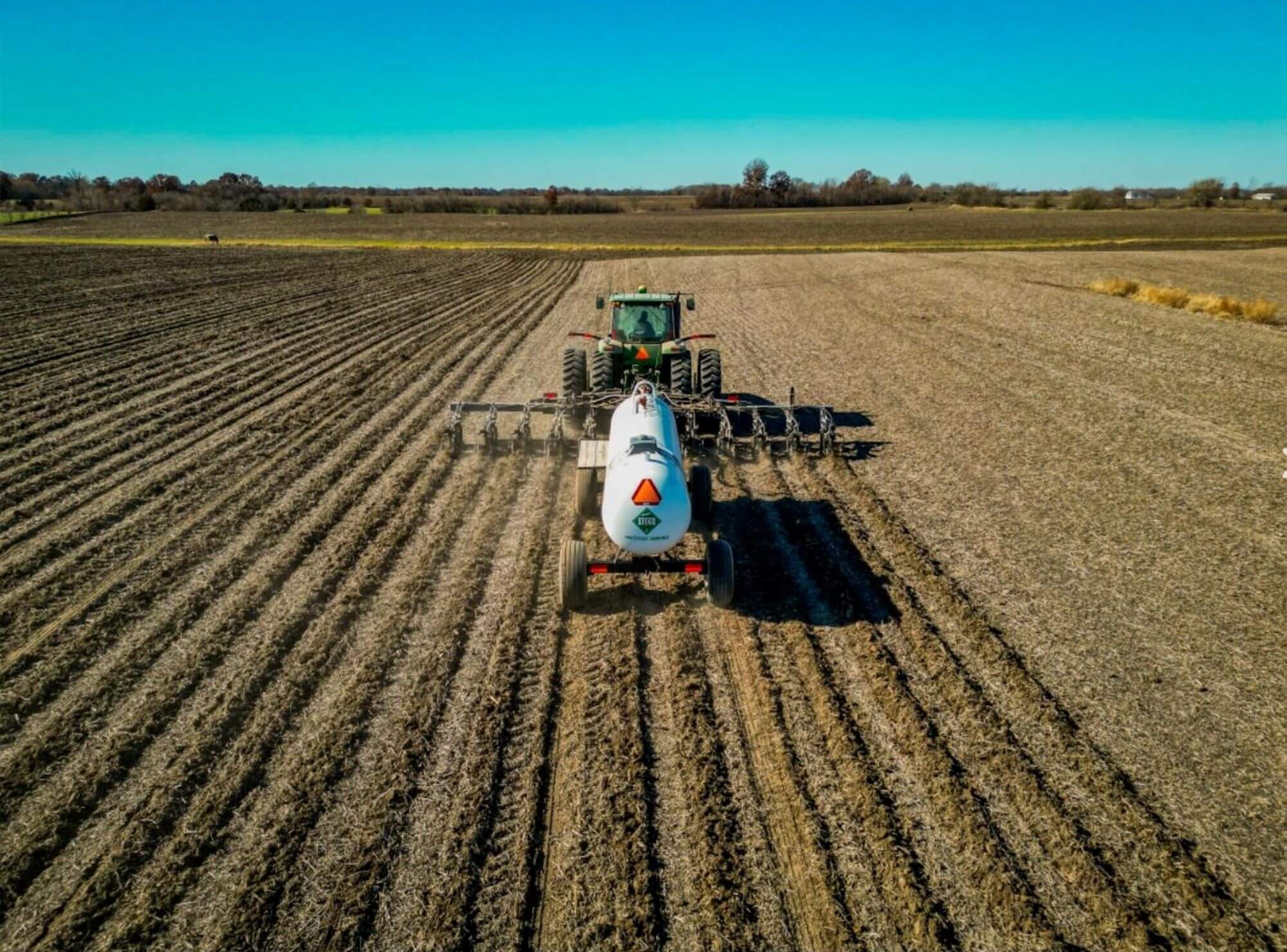 John Deere Tractor pulling Nutrien Anhydrous Tank & Fertilizer Applicator